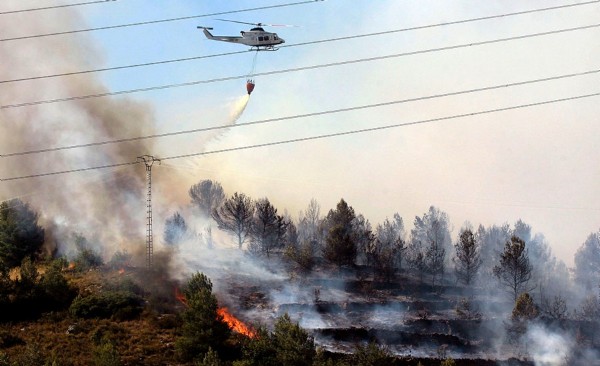 Un helicóptero en labores de extinción del incendio declarado anoche en Segorbe, que avanza hacia la sierra de Espadán y que ha provocado el desalojo de unas 140 personas del municipio de Soneja.