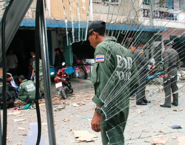 Artificieros tailandeses inspeccionan el lugar tras la explosión de un artefacto ante una tienda de comida precocinada en el distrito de Muang
