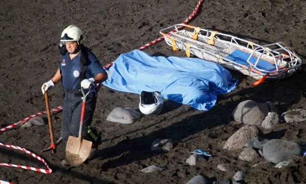 Un miembro del cuerpo de bomberos juntos a los cadáveres de las dos mujeres que han fallecido hoy tras desprenderse rocas de gran tamaño y tierra desde unos 40 metros de altura en la playa del Acantilado de Los Gigantes, en el municipio de Santiago del Teide, al suroeste de Tenerife.