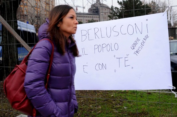 Una mujer pasa por delante de una pancarta de solidadridad con el primer ministro italiano, Silvio Berlusconi, frente al hispital San Raffaele de Milán.