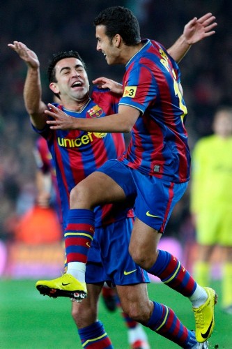 El delantero del FC Barcelona, Pedro Rodríguez (d), celebra con su compañero Xavi Hernández (i), el gol que ha marcado ante el Villarreal, el primero del equipo, durante el partido correspondiente a la decimosexta jornada de Liga que ambos equipos disputan en el estadio del Camp Nou.