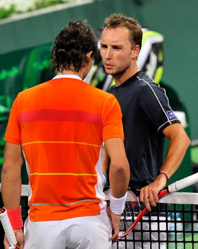 El tenista español Rafael Nadal conversa con el belga Steve Darcis tras clasificarse para las semifinales del Torneo de Doha en apenas treinta y cinco minutos por 6-1, 2-0 y retirada.