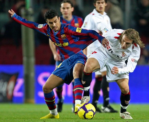 El delantero del FC Barcelona Pedro (izda) pelea por el control del balón con el jugador del Sevilla, Diego Capel, durante el partido de ida de los octavos de final de la Copa del Rey disputado en el Camp Nou de Barcelona.