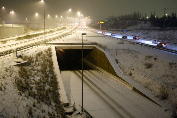 Varios coches circulan por la M-50, cubierta por la nieve después de las fuertes nevadas que se han registrado en la capital de España.