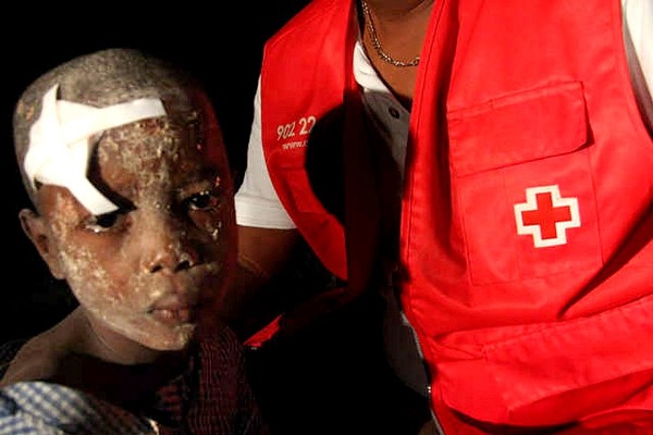 Un niño herido en el terremoto es atendido por un miembro de la Cruz Roja.