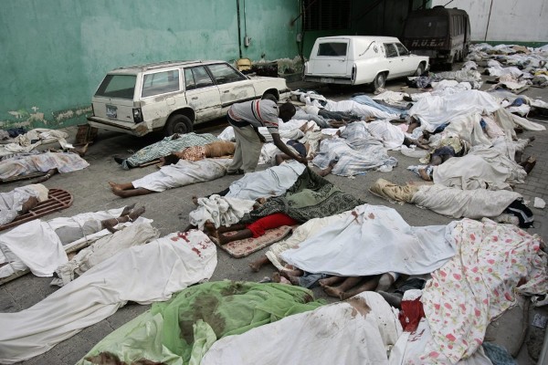 Un hombre busca un familiar entre varios cadáveres en la morgue de Puerto Príncipe.