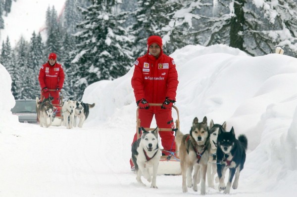 Los pilotos de Ferrari Felipe Massa, (i), y Fernando Alonso, conducen trineos tirados por perros durante una jornada de nieve en Madonna di Campiglio.