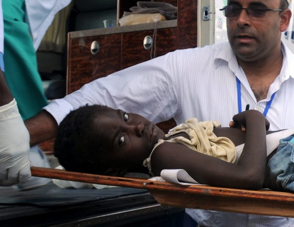 Una niña haitiana herida es transportada en una camilla.