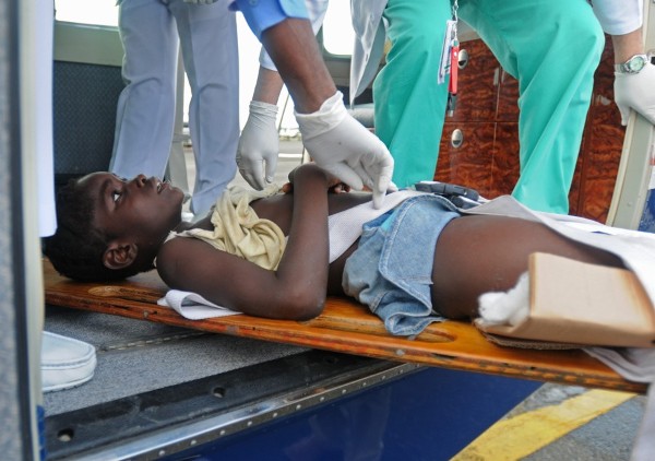Una niña haitiana herida es transportada en una camilla.