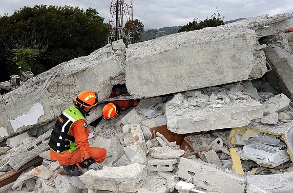 Bomberos surcoreanos de los equipos de rescate entre los escombros del Hotel Montana de Puetro Príncipe.