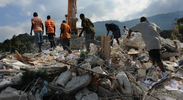 Algunos jóvenes buscan a sus compañeros de colegio sobre los escombros de la escuela Canape-vert, en Puerto Príncipe.