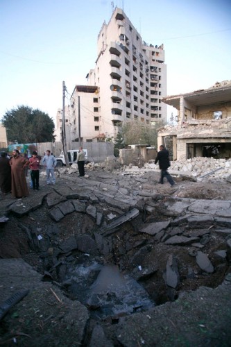 Iraquíes observan el cráter que ha ocasionado la explosión de un coche bomba frente al hotel Alhamraa de Bagdad.