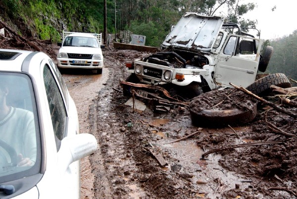Dos vehículos circulan por una carretera destrozada en Ribeira Brava.