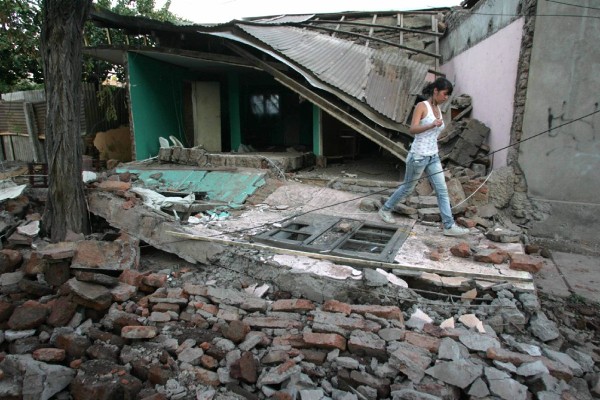 Una joven camina cerca a una vivienda destruida en Santiago (Chile).