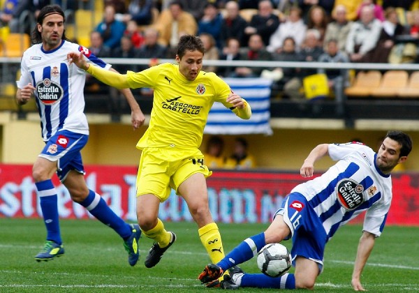 El centrocampista del Deportivo, Antonio Tomás (d) y el centrocampista del Villarreal, David Fuster (8) luchan por el balón durante el partido correspondiente a la vigésimo cuarta jornada de Liga.