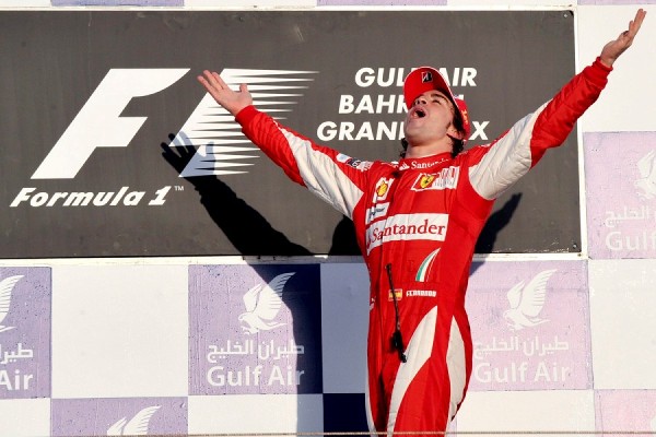 El piloto español de la escudería Ferrari, Fernando Alonso, celebra en el podio su victoria en el Gran Premio de Bahrein.