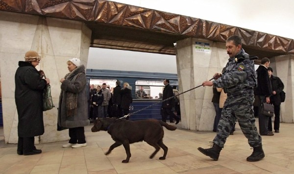 Un miembro de la policía del metro patrullando con su perro entrenado para detectar bombas la estación 