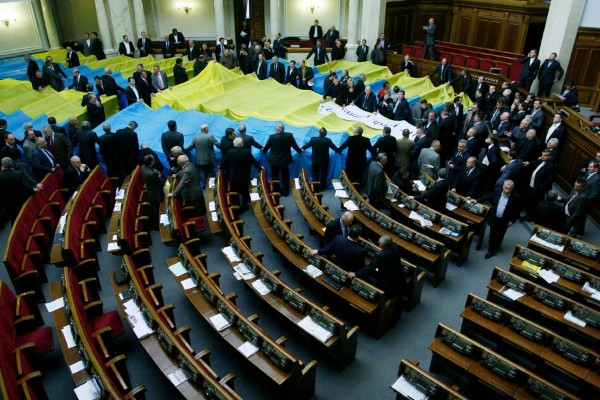 Miembros de la oposición parlamentaria ucraniana cubren sus escaños con los colores de la bandera ucraniana en el Parlamento en Kiev (Ucrania).