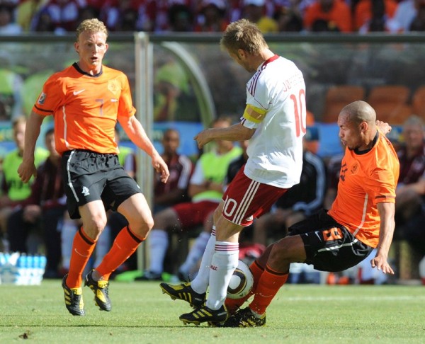 El jugador danés Martin Jorgensen (c) lucha por el balón con Dirk Kuyt (i) y Nigel de Jong.