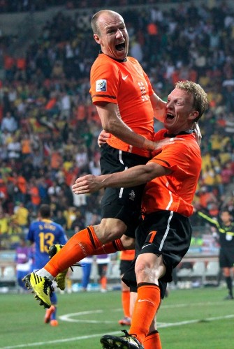 Los jugadores holandeses Arjen Robben (i) y Dirk Kuyt se abrazan después del disparo de Wesley Sneijder que finalizó en el autogol de Felipe Melo (Brasil) durante el partido Holanda-Brasil, de cuartos de final del Mundial de Sudáfrica 2010, en el estadio Nelson Mandela Bay de Puerto Elizabeth (Sudáfrica) hoy, viernes 2 de julio de 2010. Holanda ganó el encuentro por 2-1 y se clasificó para las semifinales.