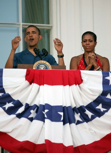 El presidente de Estados Unidos, Barack Obama (i), y su esposa, la primera dama Michelle Obama (d), saludan hoy, domingo 4 de julio de 2010, desde el balcón del Jardín Sur de la Casa Blanca en Washington, DC (EEUU), a militares y sus familias durante la celebración de la independencia del país.