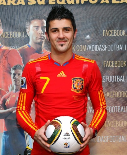 El delantero de la selección española de fútbol David Villa posa con el balón oficial del Mundial de Sudáfrica 2010 y el modelo de camiseta que lucirá el equipo español en el partido de mañana en Durban ante Alemania correspondiente a las semifinales del Mundial sudafricano.