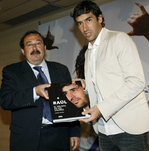 El delantero del Real Madrid Raúl González (d) y el periodista Enrique Ortego posan con un ejemplar del libro 