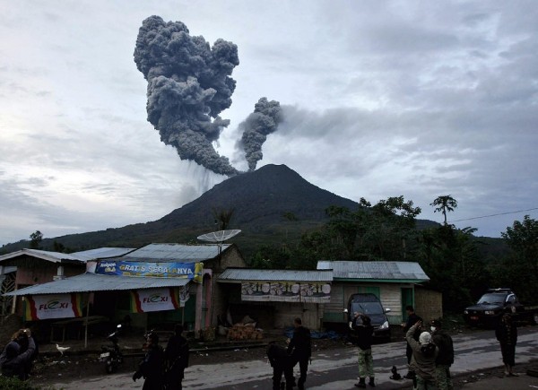 Residentes de la ciudad de Medan observan el volcán Monte Sinabung.