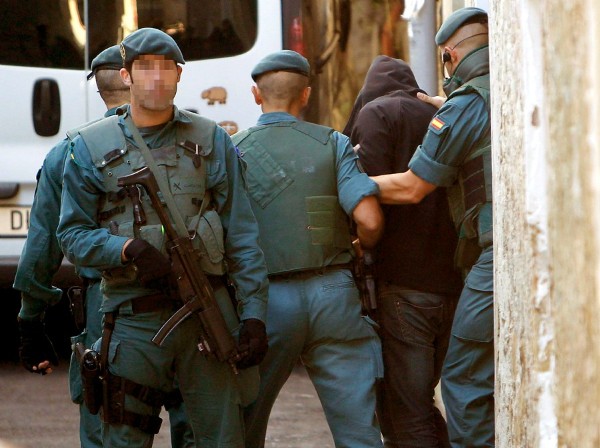 Varios guardias civiles se llevan detenido a un hombre.