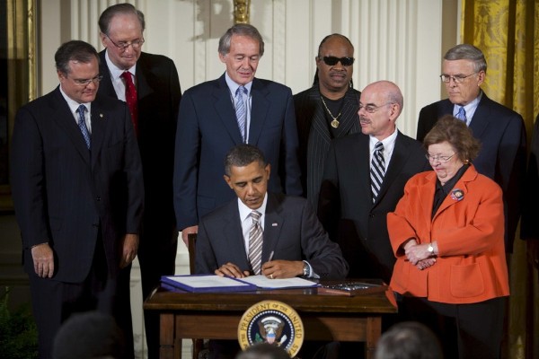 El presidente de los Estados Unidos, Barack Obama, rodeado de legisladores demócratas, y el cantante Stevie Wonder, (4-d), firma la ley 