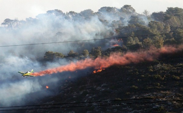 Una avioneta trabaja en la extinción de un incendio forestal registrado cerca de la localidad de Haifa.