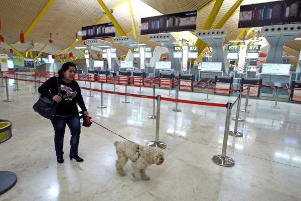 Una mujer pasea a un perro la Terminal T-4 del aeropuerto de Madrid-Barajas.