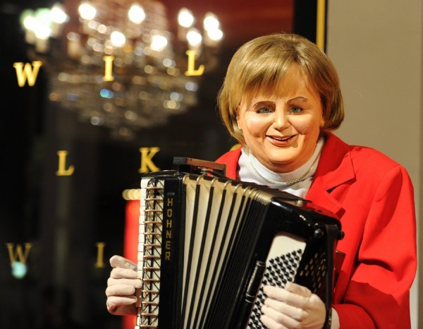 Una muñeca de la canciller alemana, Angela Merkel, tocando el acordeón permanece a la entrada del Hotel Intercontinental en Berlín.