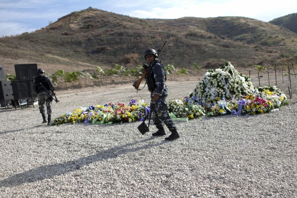 Un policía pasa ante varias coronas de flores ubicadas en St Christophe, Titanyen, a las afueras de Puerto Príncipe.