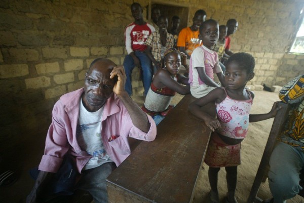 Refugiados de Costa de Marfil descansan en un centro para registrar refugiados en Nimba, Liberia.