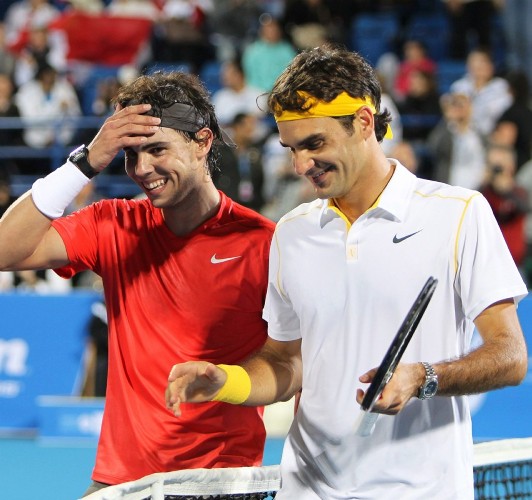 El tenista español Rafael Nadales felicitado por el suizo Roger Federer (d) al término de la final del torneo de exhibición de Abu Dabi.