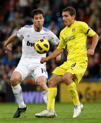 El centrocampista del Real Madrid Xabi Alonso (i) lucha un balón con el delantero argentino del Villarreal Marco Ruben.