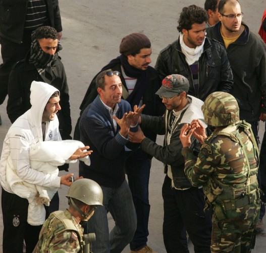 Unos manifestantes discuten con unos soldados durante las protestas en contra del presidente tunecino.