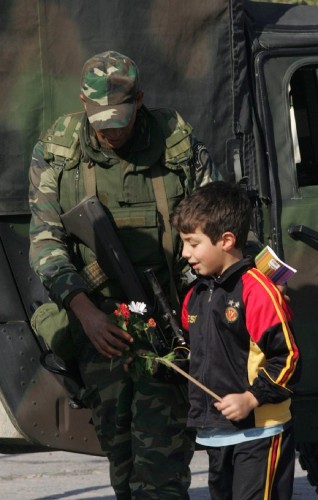 Un niño le da unas flores a un soldado tunecino.