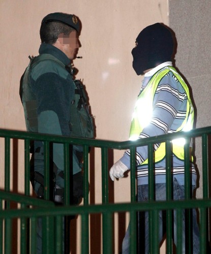 Efectivos de la Guardia Civil abandonan un domicilio del barrio de la Rochapea, en Pamplona, tras el registro efectuado.