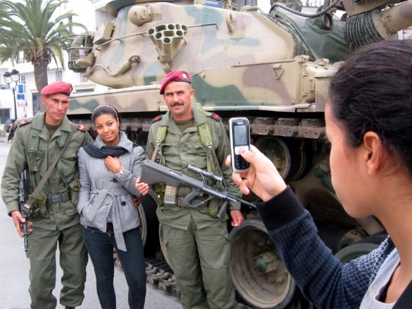 Una mujer posa junto a dos soldados para una foto en Gammarth.