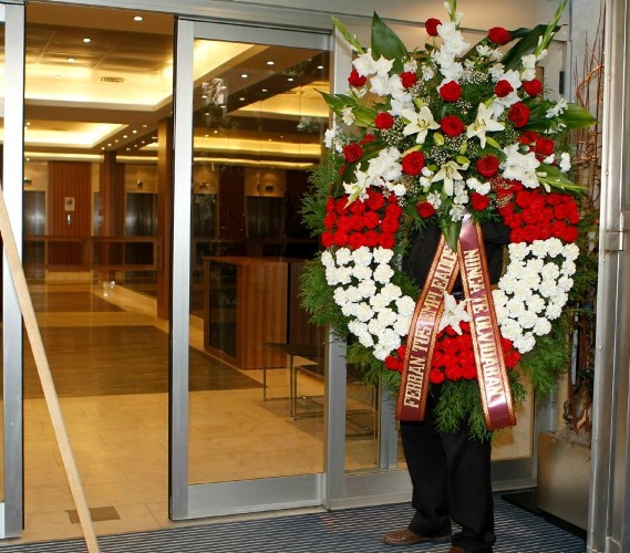 Una corona de flores enviada por los trabajadores de Viajes Marsans llega a la sede de la CEOE en Madrid.