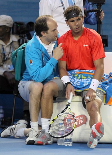 El tenista español David Ferrer (d) habla con un preparador.