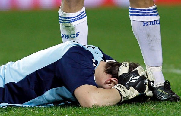 El guardameta del Real Madrid, Iker Casillas tendido sobre el terreno de juego tras recibir un impacto en la cabeza al término del partido.