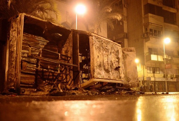Un coche calcinado permanece volcado en una calle de El Cairo.