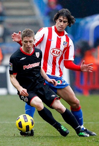 El mediocentro portugués del Atlético de Madrid Tiago Mendes (d) lucha por un balón con el centrocampista del Athletic de Bilbao Iker Muniain.