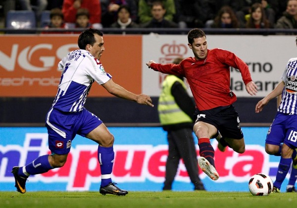 El centrocampista de Osasuna, Álvaro Cejudo (d), se dispone a golpear el balón ante el defensor del Deportivo de la Coruña, Antonio Tomás.