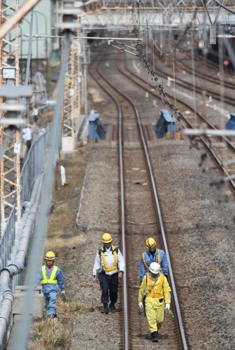 Los trabajadores inspeccionan las vías en la estación Higashi.
