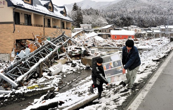 Mientras la nieve y las bajas temperaturas regresan, dos jóvenes llevan ropa para sus familiares en Kesennuma.