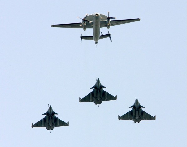 Un EC2 Hawkeye (arriba) sobrevolando los Campos Elíseos mientras es escoltado por tres cazas Rafale, durante el desfile militar por el Día de la Bastilla, en París (Francia).